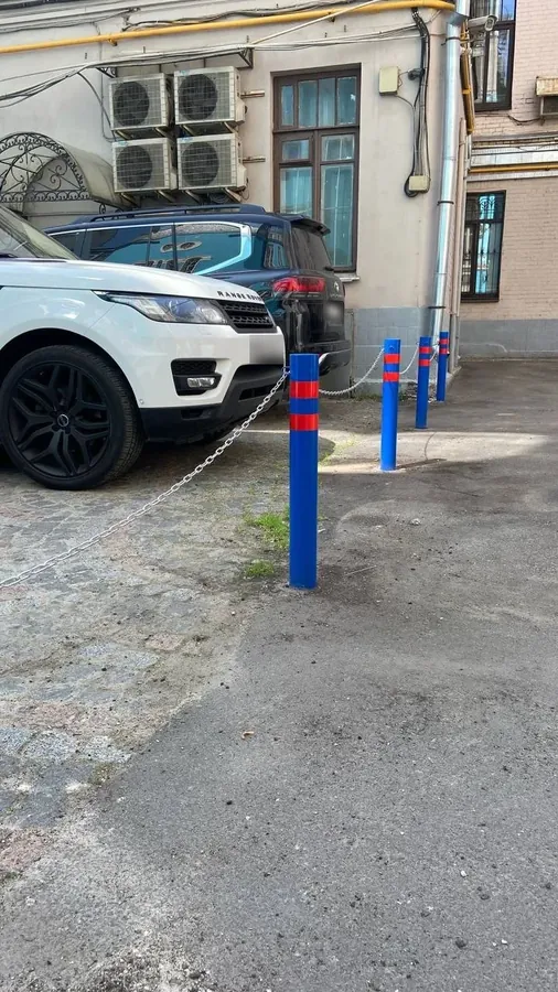 Blue bollards with a chain in a courtyard