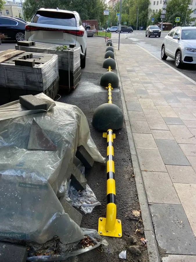 Barrier rail and bollards fitted beside a pavement
