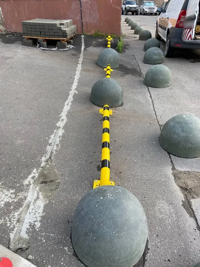 Barrier rail between concrete bollards in a yard