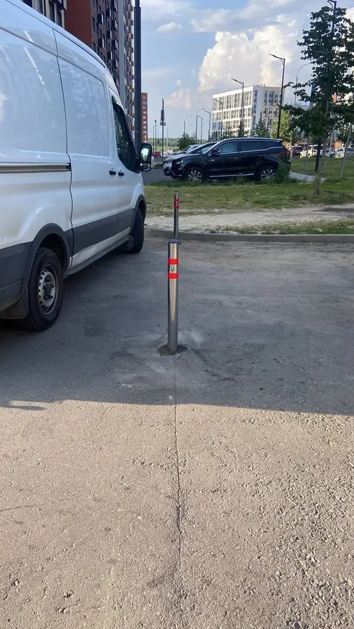 Steel bollard at the edge of a car park