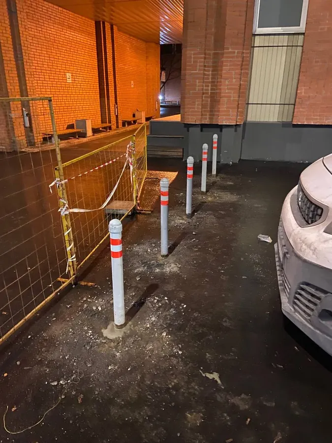 Bollards with reflective bands by a building at night